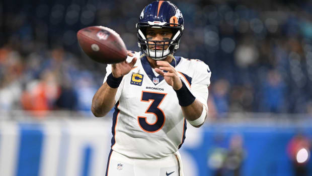 Broncos quarterback Russell Wilson catches a football during warmups before a game.